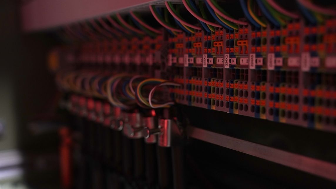 De nombreux câbles et conducteurs sont raccordés et organisés dans une armoire de distribution.