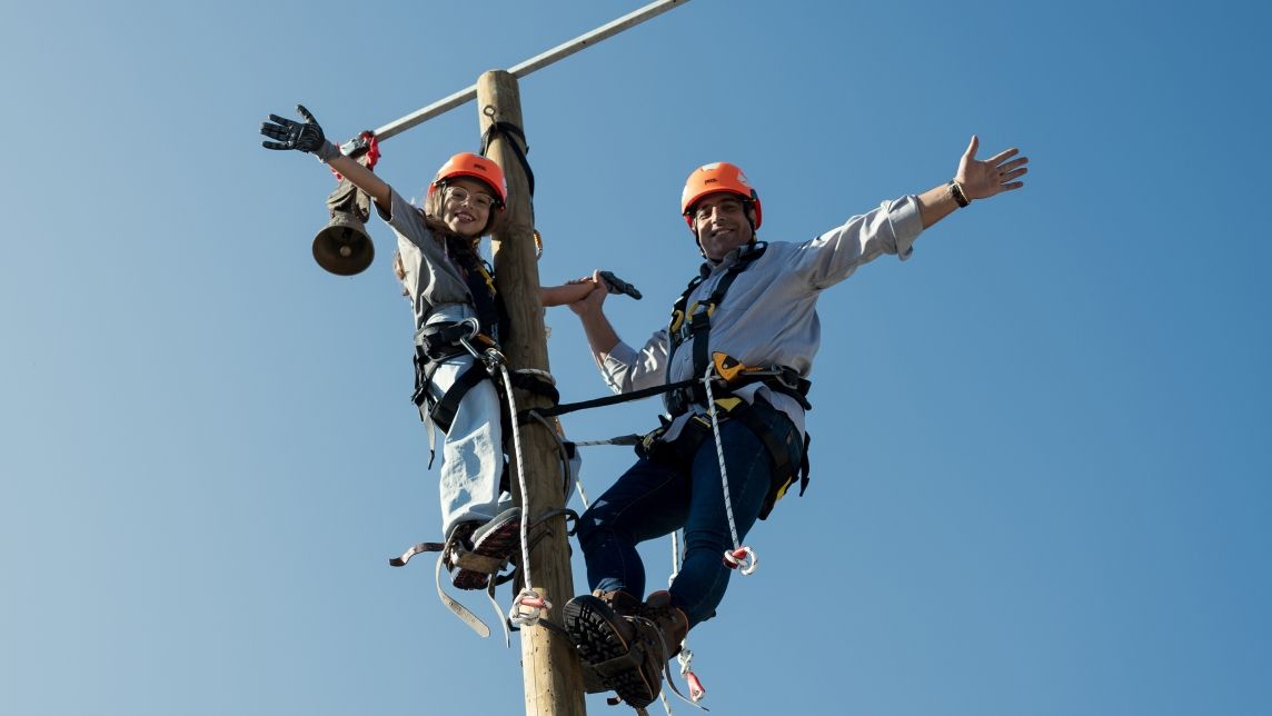 Un bambino e un uomo si arrampicano su un palo di legno