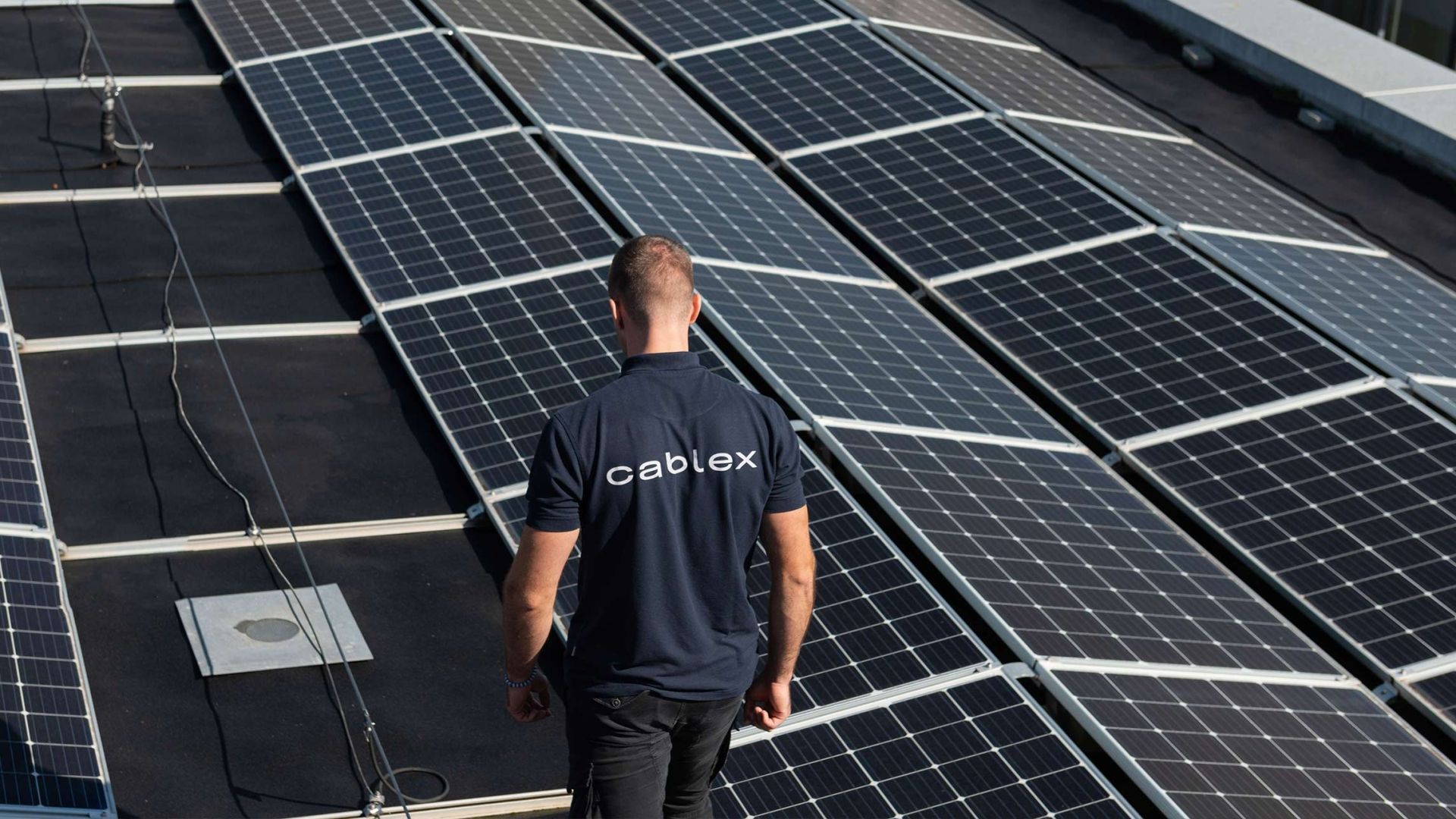 cablex employee before solar panel on roof.