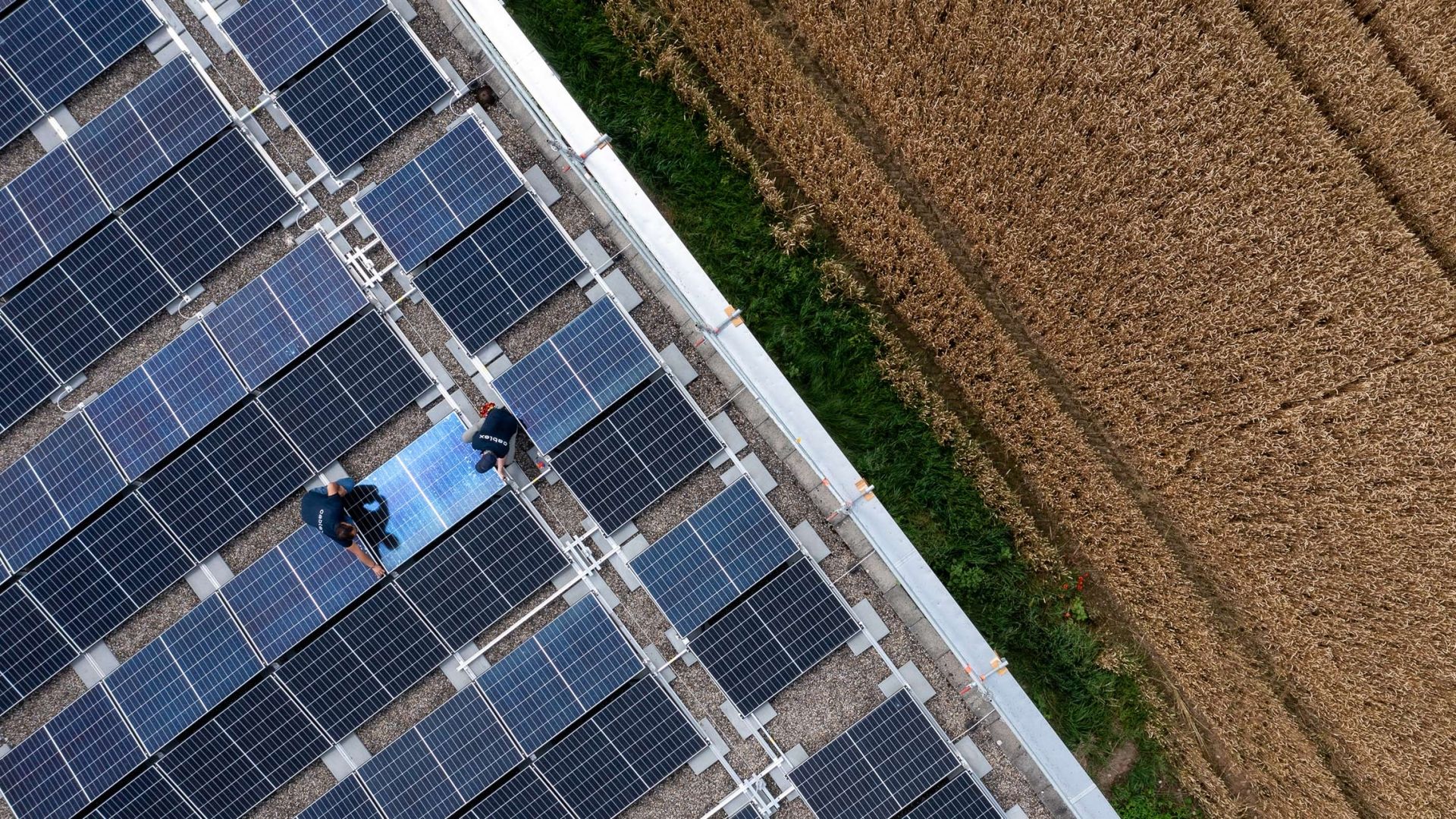 Zwei cablex Techniker auf dem Dach bei Solarpanels.