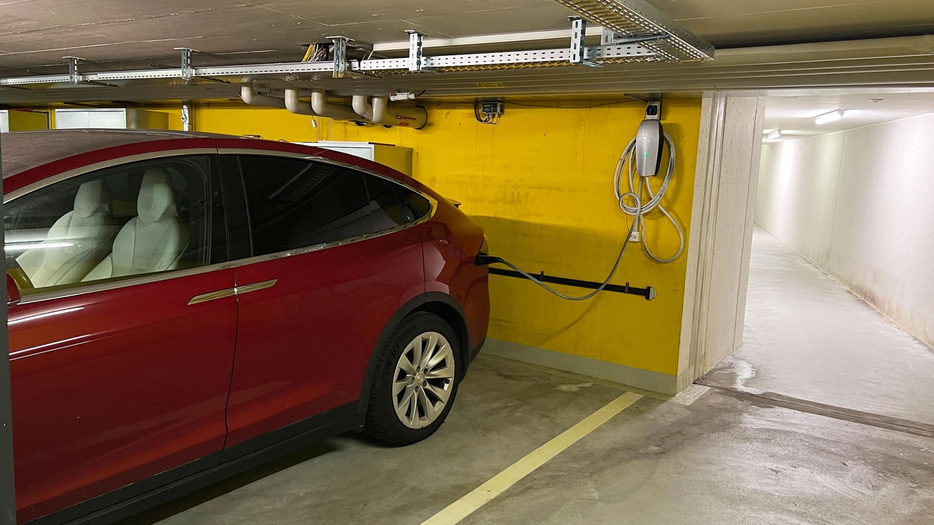 E-Auto lädt an E-Mobility Station in der Garage.