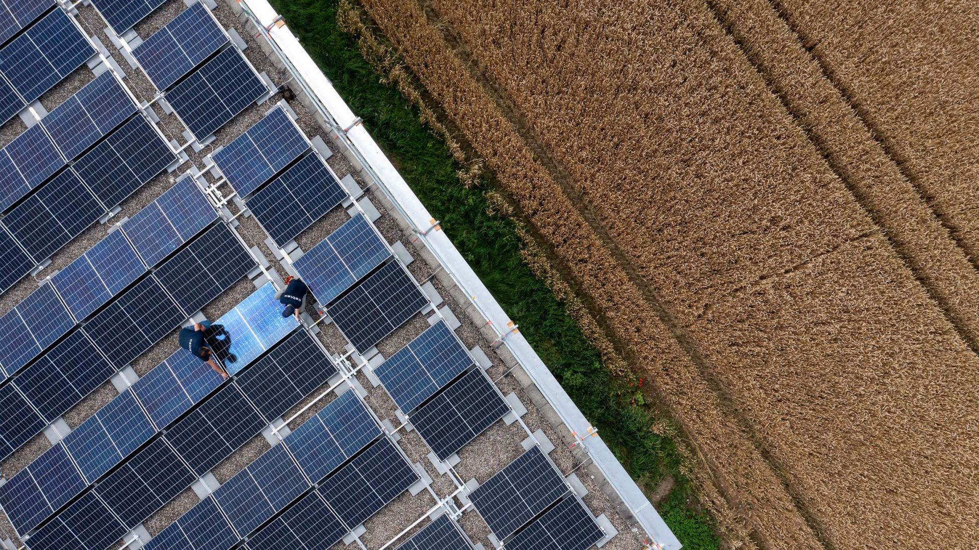 Zwei cablex Techniker arbeiten auf einem Dach an einer Photovoltaikanlage.