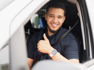 Le cablex technicien sourit en regardant par la fenêtre de la voiture.