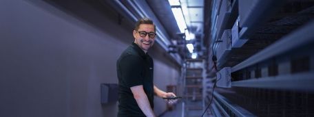 Technicien cablex dans la salle de commande, iPad à la main.