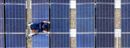 Drohnenaufnahme eines cablex Technikers auf einem Dach mit Photovoltaik-Modulen