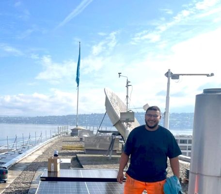 cablex Techniker steht auf dem Dach mit den verlegten Solarpaneelen.