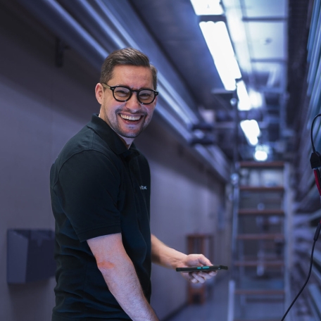 cablex Techniker im Schaltraum mit iPad in der Hand.