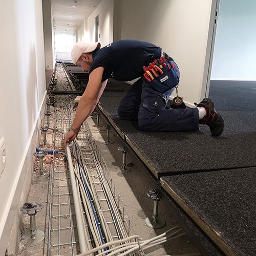 Apprentice assembly electrician working in a company building.