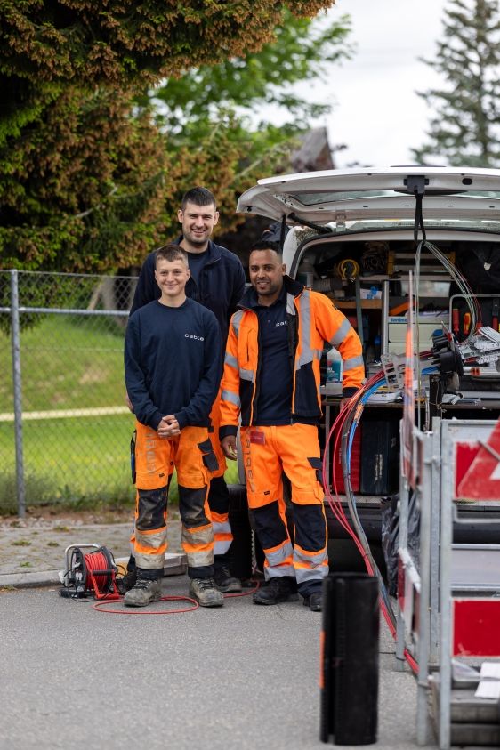 Three cablex technicians stand in front of a splice bus.