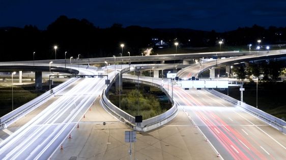 Drohnenaufnahme einer Autobahn bei Nacht.