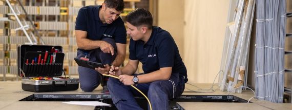 Montage Elektriker bei cablex verlegt Kabel am Boden